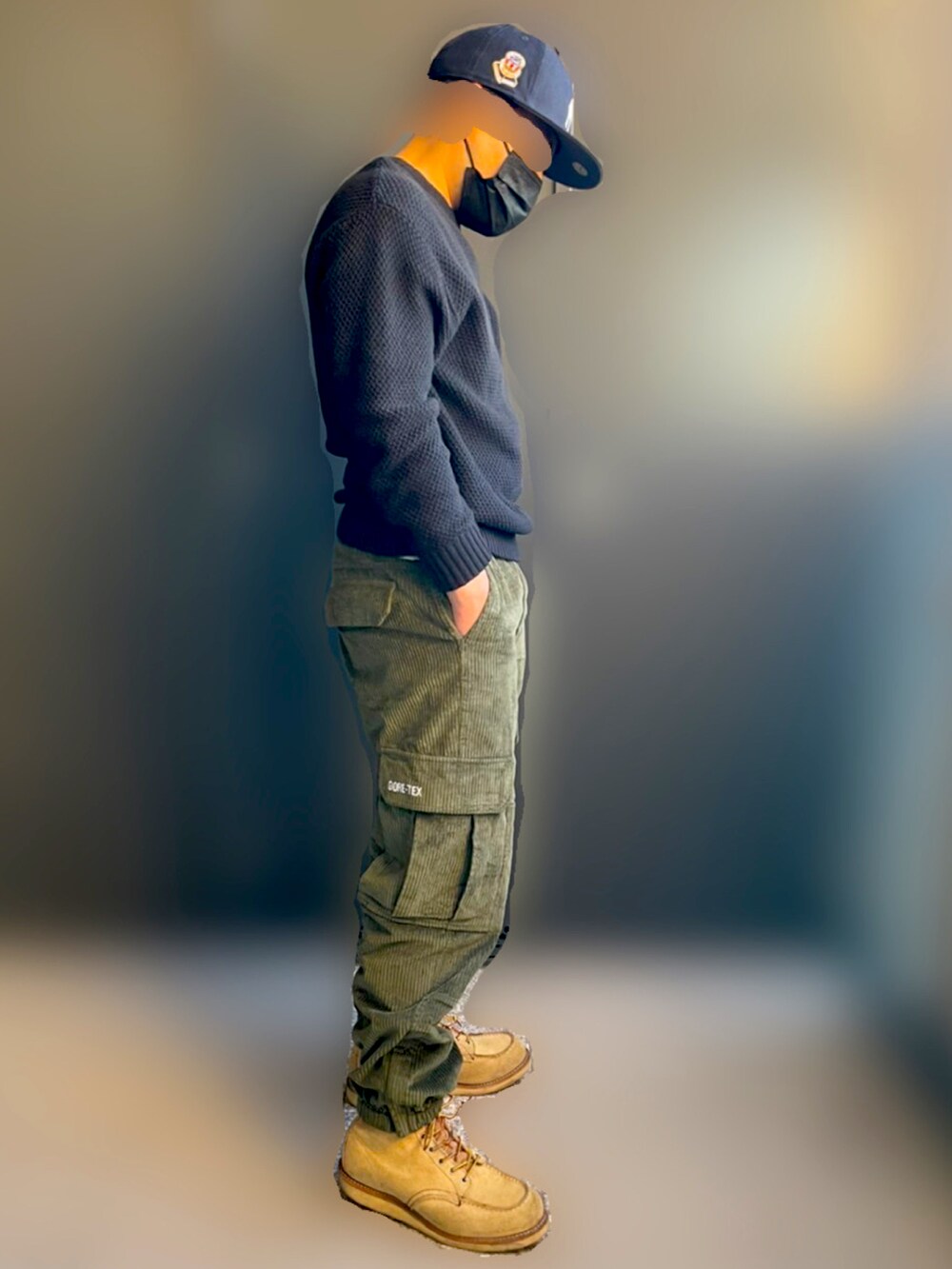 ブラック系のニット/セーター、グリーン系のカーゴパンツ、ベージュ系のブーツを着用したメンズの秋コーディネートの2枚目の写真