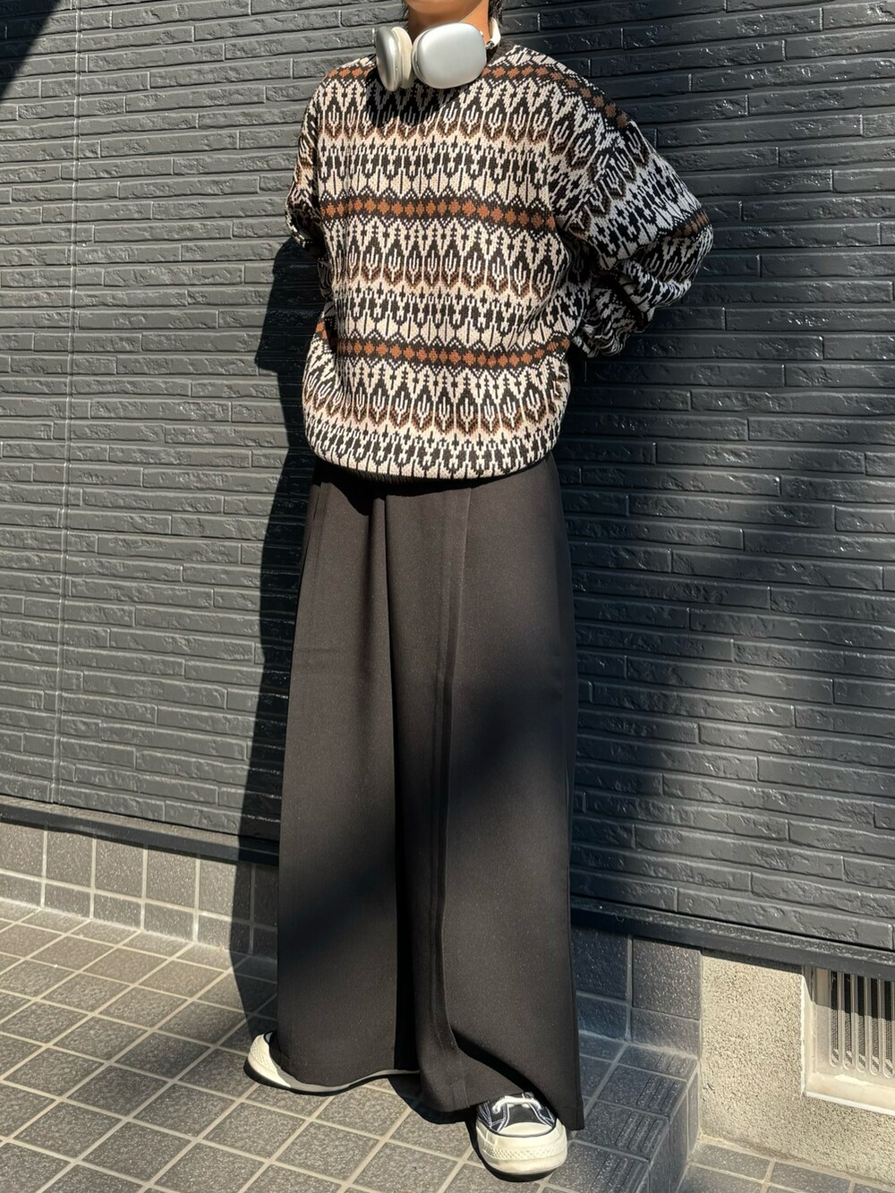 ブラウン系のニット/セーター、ブラック系のスラックスを着用したメンズの秋コーディネートの3枚目の写真