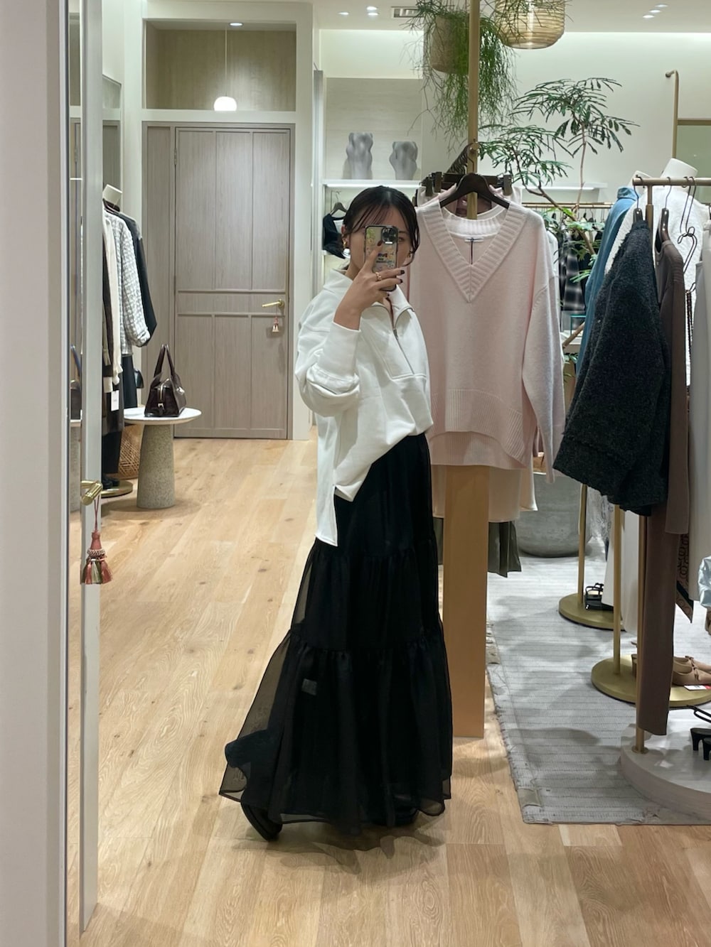 ブラック系のスカート、ホワイト系のスウェット、ブラック系のその他シューズを着用したレディースの春コーディネートの5枚目の写真