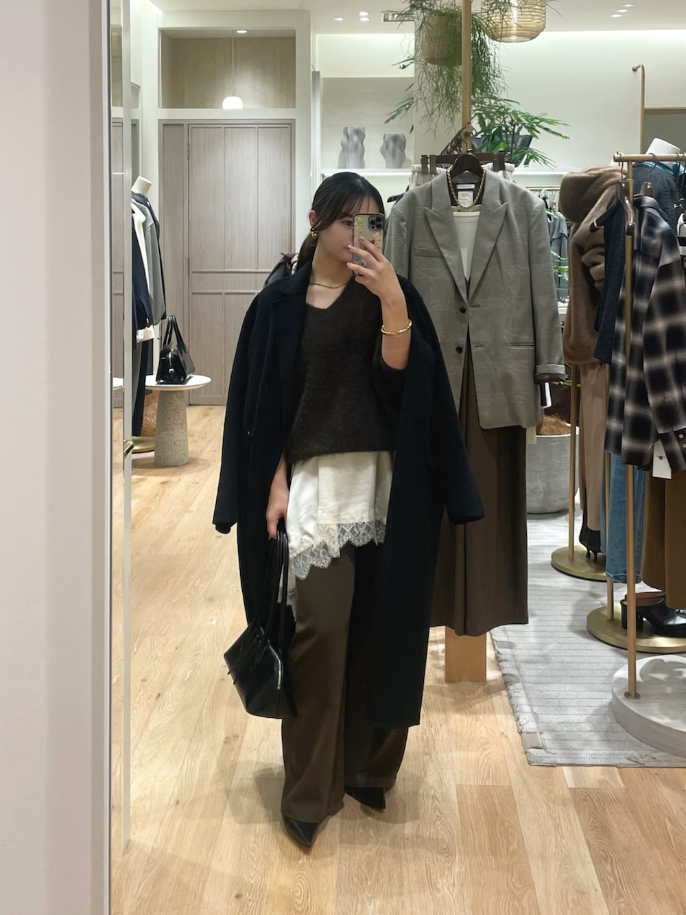 ブラウン系のニット/セーター、ホワイト系のキャミソール、ブラウン系のその他パンツを着用したレディースの冬コーディネートの4枚目の写真