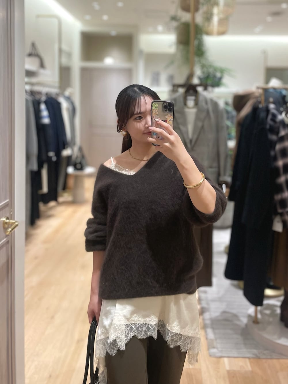 ブラウン系のニット/セーター、ホワイト系のキャミソール、ブラウン系のその他パンツを着用したレディースの冬コーディネートの2枚目の写真