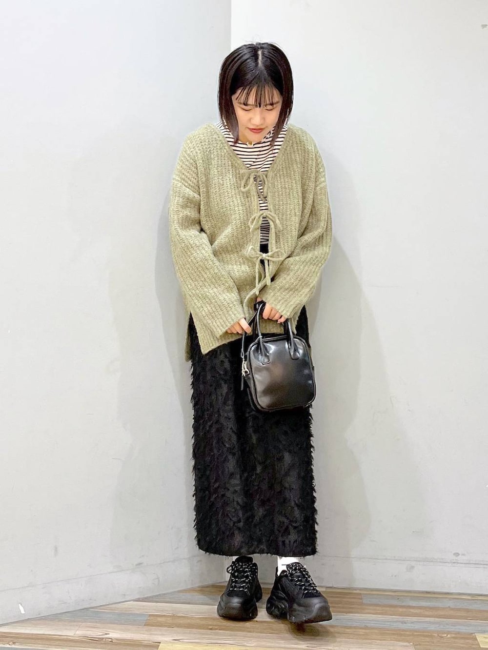 ホワイト系のTシャツ/カットソー、ブラック系のボストンバッグ、ブラック系のスニーカーを着用したレディースの冬コーディネートの6枚目の写真