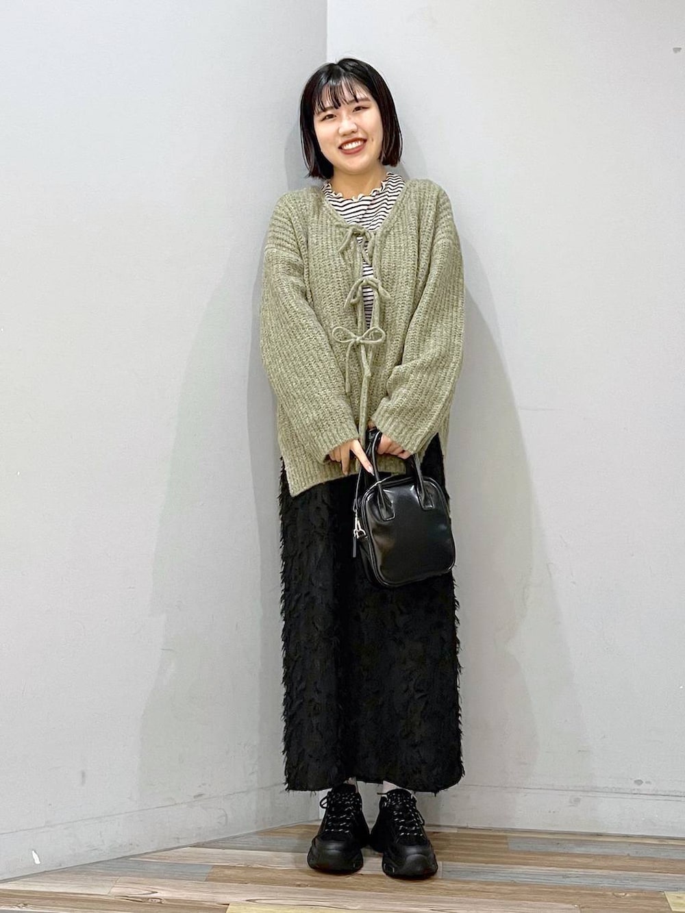 ホワイト系のTシャツ/カットソー、ブラック系のボストンバッグ、ブラック系のスニーカーを着用したレディースの冬コーディネートの2枚目の写真