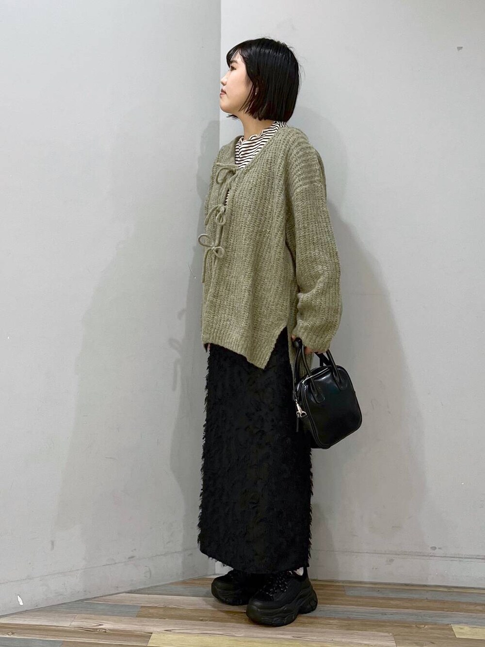 ホワイト系のTシャツ/カットソー、ブラック系のボストンバッグ、ブラック系のスニーカーを着用したレディースの冬コーディネートの3枚目の写真