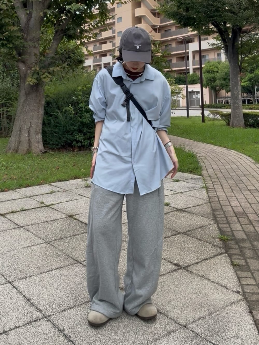 グレー系のスウェットパンツ、ベージュ系のサンダル、ブルー系のシャツ/ブラウスを着用したレディースの秋コーディネートの2枚目の写真