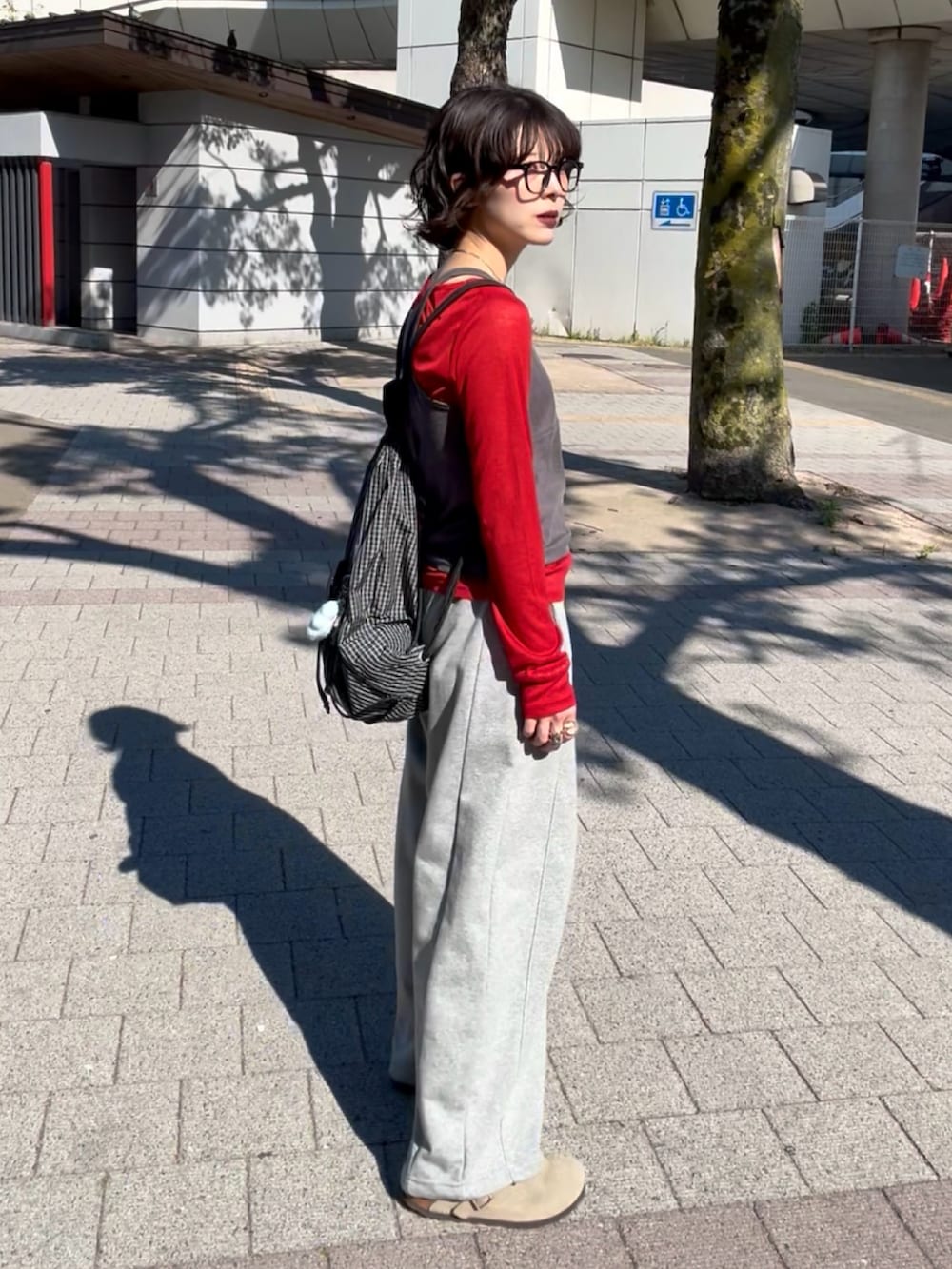 グレー系のTシャツ/カットソー、グレー系のスウェットパンツ、ベージュ系のサンダルを着用したレディースの春コーディネートの2枚目の写真