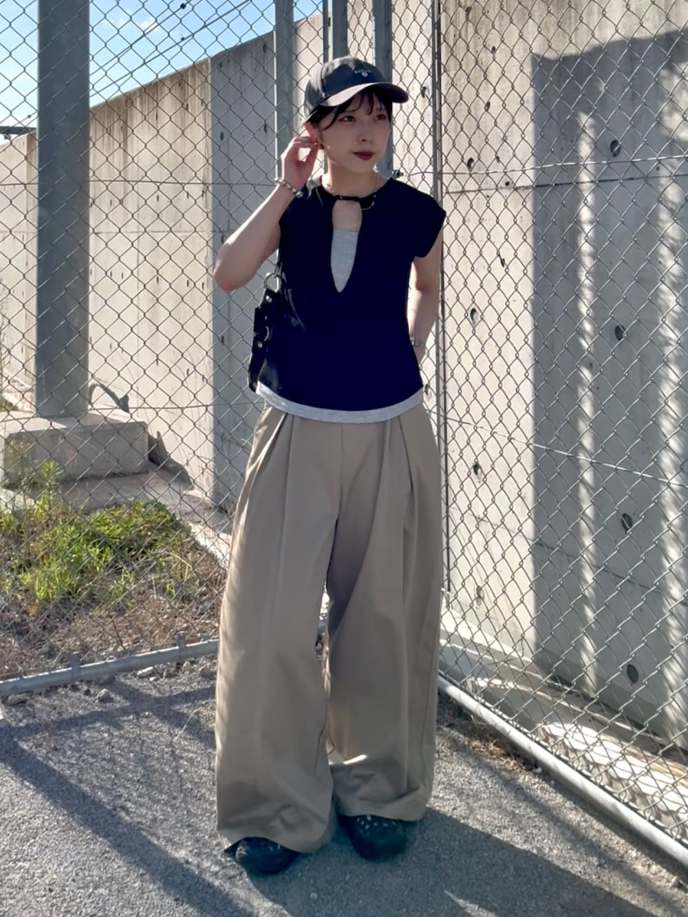 ブラック系のTシャツ/カットソー、ベージュ系のチノパンツ、ブラック系のサンダルを着用したレディースの夏コーディネートの3枚目の写真