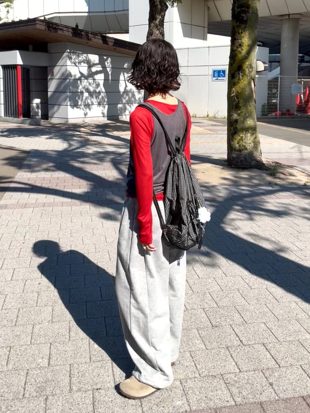 グレー系のTシャツ/カットソー、グレー系のスウェットパンツ、ベージュ系のサンダルを着用したレディースの春コーディネートの3枚目の写真