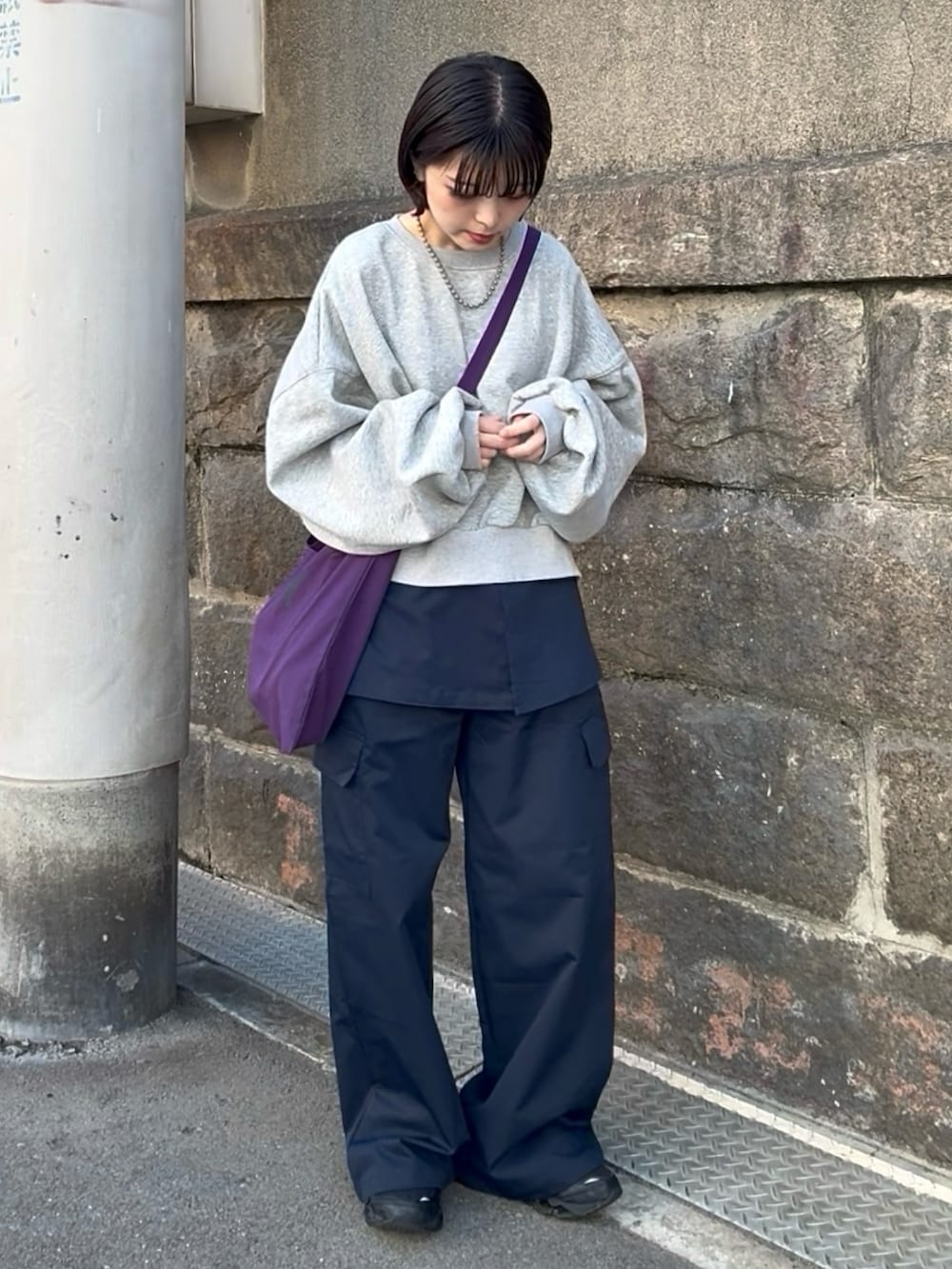 ブルー系のカーゴパンツ、グレー系のスウェット、レッド系のトートバッグを着用したレディースの春コーディネートの3枚目の写真