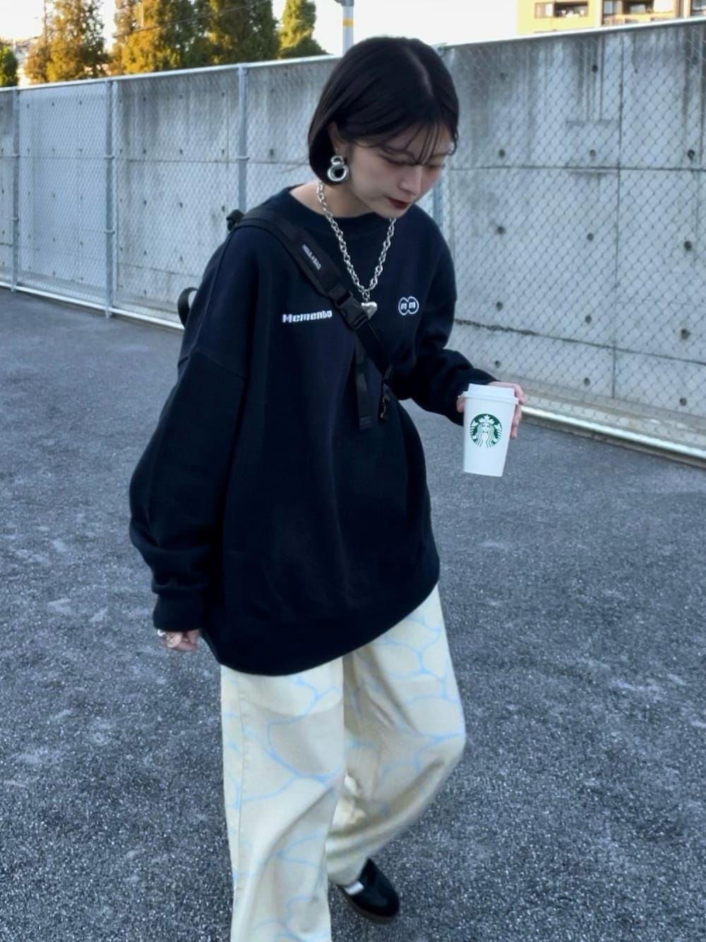 イエロー系のパンツ、ブラック系のスニーカー、ブルー系のスウェットを着用したレディースの春コーディネートの2枚目の写真