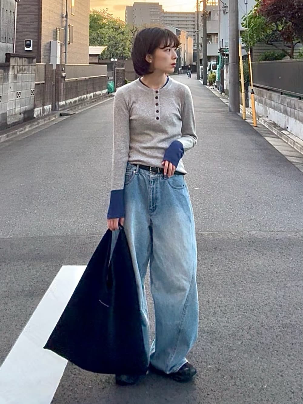 その他のニット/セーター、ブルー系のデニムパンツ、ブラック系のスニーカーを着用したレディースの春コーディネートの2枚目の写真