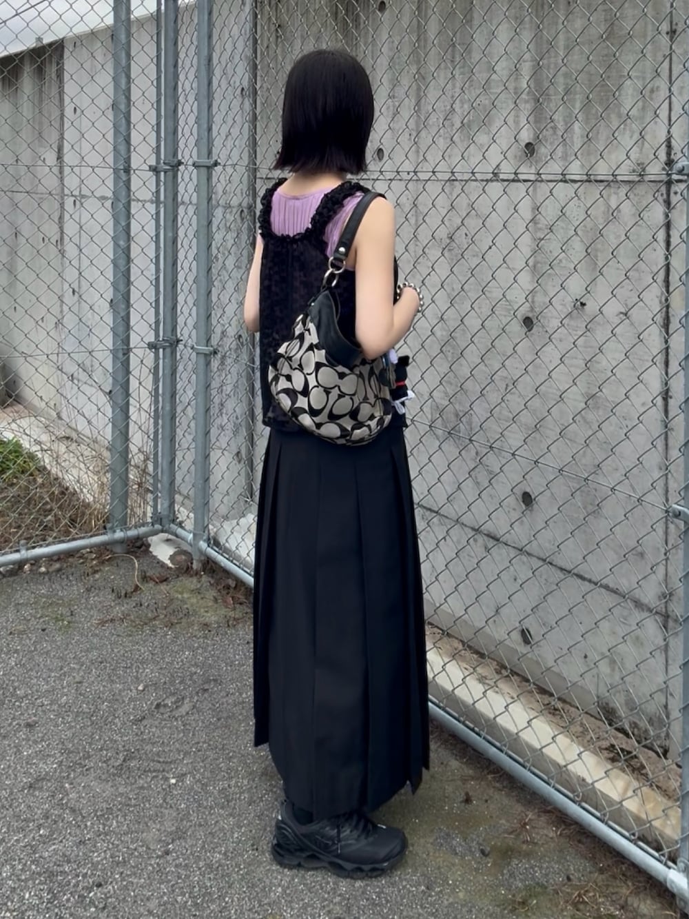 ブラック系のスカート、ブラック系のスニーカー、ブラック系のトップスを着用したレディースの夏コーディネートの3枚目の写真