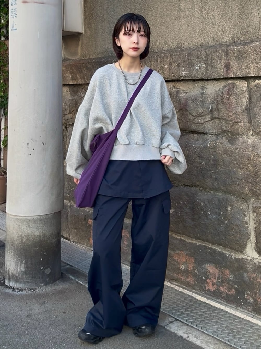 ブルー系のカーゴパンツ、グレー系のスウェット、レッド系のトートバッグを着用したレディースの春コーディネートの2枚目の写真
