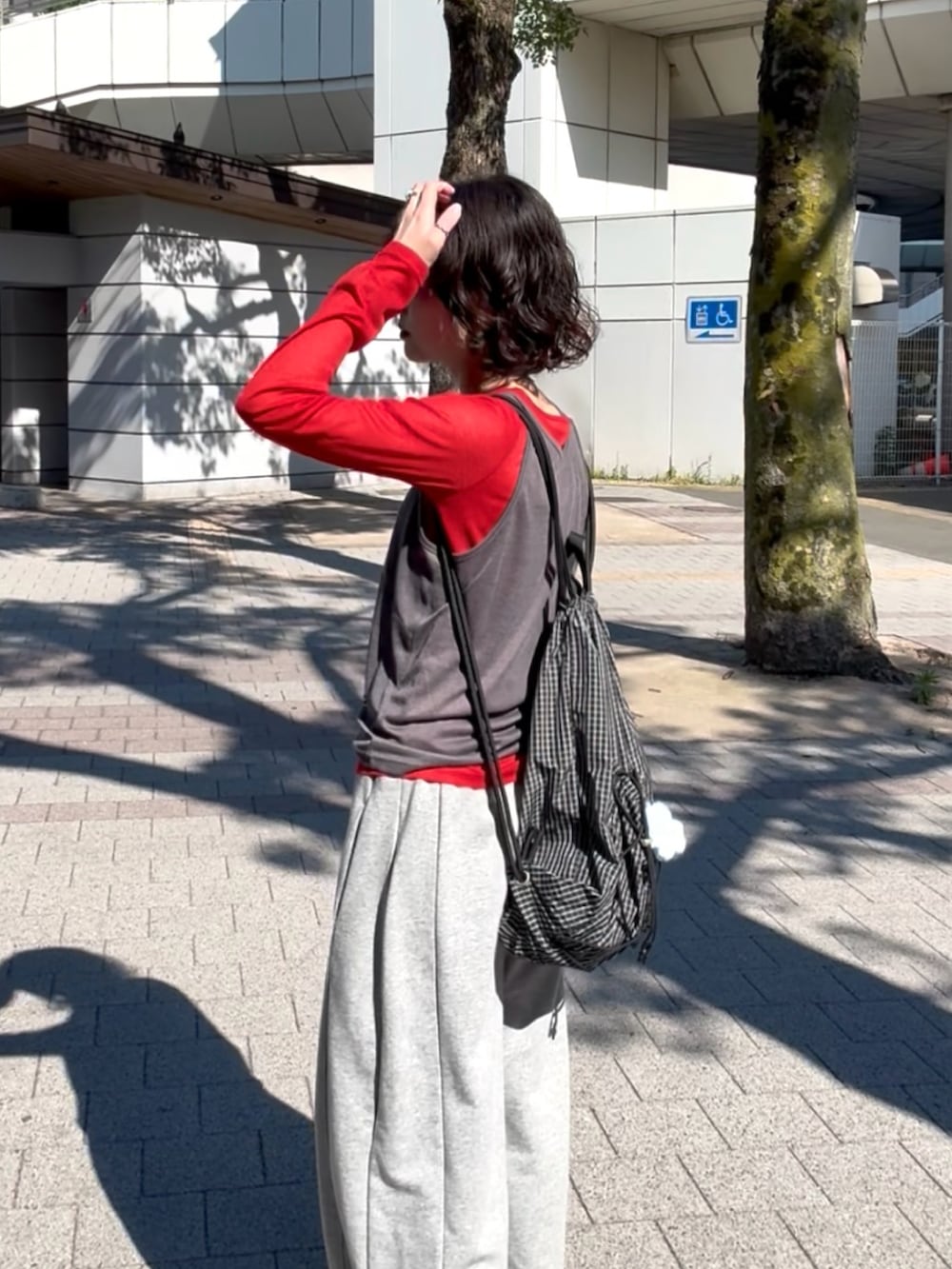 グレー系のTシャツ/カットソー、グレー系のスウェットパンツ、ベージュ系のサンダルを着用したレディースの春コーディネートの4枚目の写真