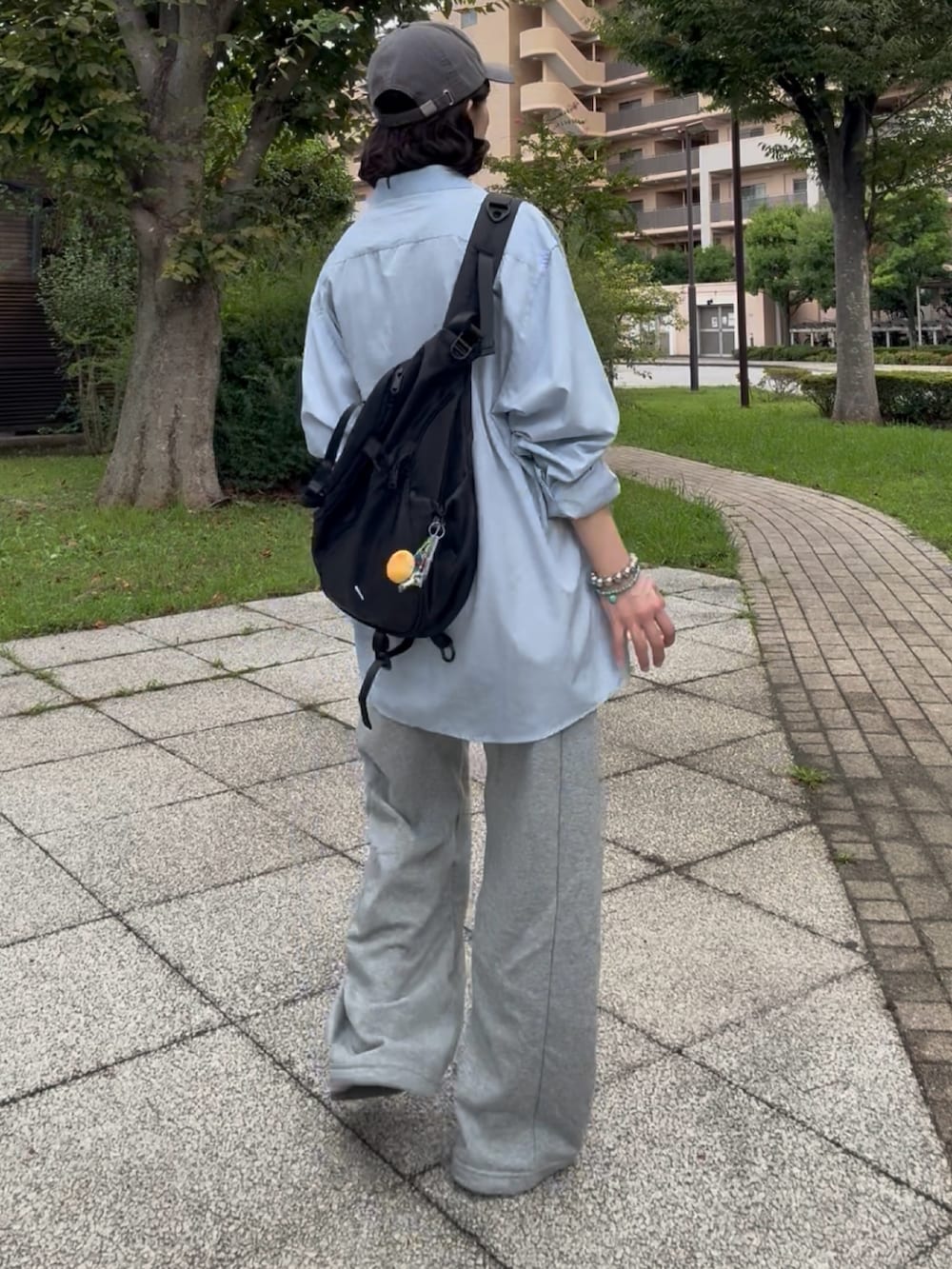 グレー系のスウェットパンツ、ベージュ系のサンダル、ブルー系のシャツ/ブラウスを着用したレディースの秋コーディネートの3枚目の写真