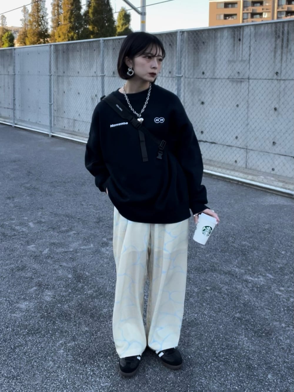 イエロー系のパンツ、ブラック系のスニーカー、ブルー系のスウェットを着用したレディースの春コーディネートの3枚目の写真