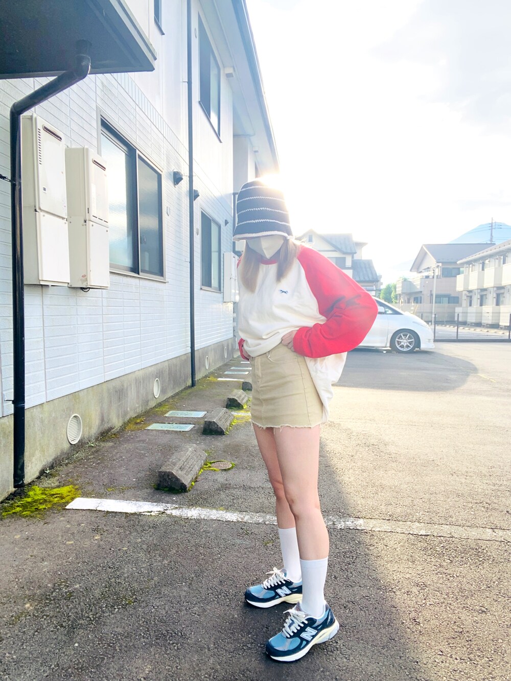 ベージュ系のデニムスカート、ホワイト系のスウェット、ブルー系のスニーカーを着用したレディースの秋コーディネートの2枚目の写真