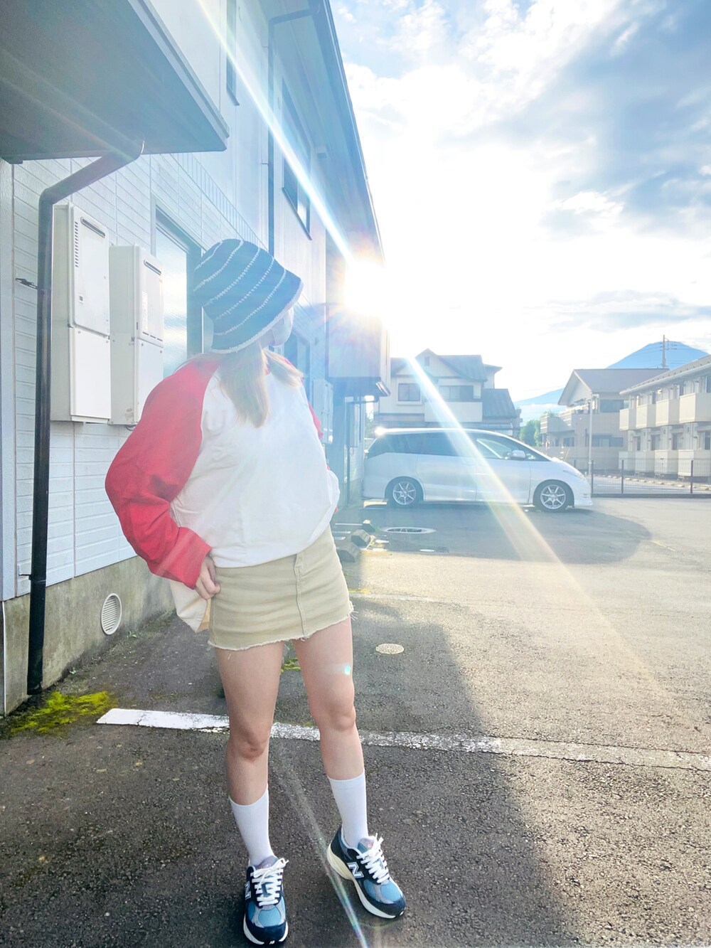 ベージュ系のデニムスカート、ホワイト系のスウェット、ブルー系のスニーカーを着用したレディースの秋コーディネートの3枚目の写真