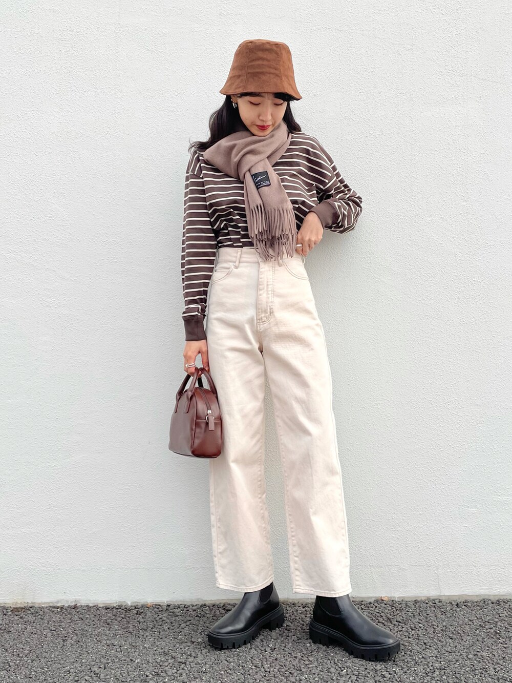 ブラック系のTシャツ/カットソー、ホワイト系のデニムパンツ、ブラウン系のショルダーバッグを着用したレディースの冬コーディネートの2枚目の写真