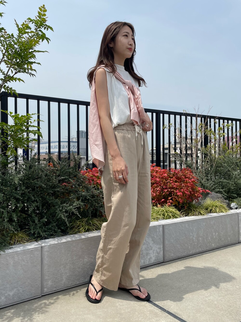 ベージュ系のその他パンツ、ピンク系のシャツ/ブラウス、ブラック系のサンダルを着用したレディースの夏コーディネートの2枚目の写真