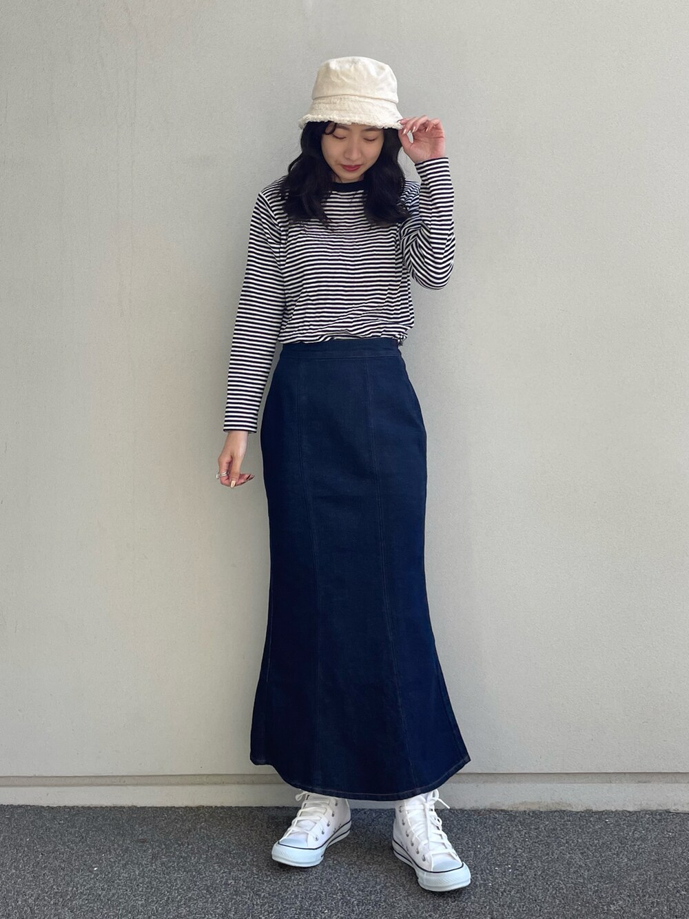 ホワイト系のTシャツ/カットソー、ブルー系のデニムスカート、ホワイト系のその他シューズを着用したレディースの冬コーディネートの2枚目の写真