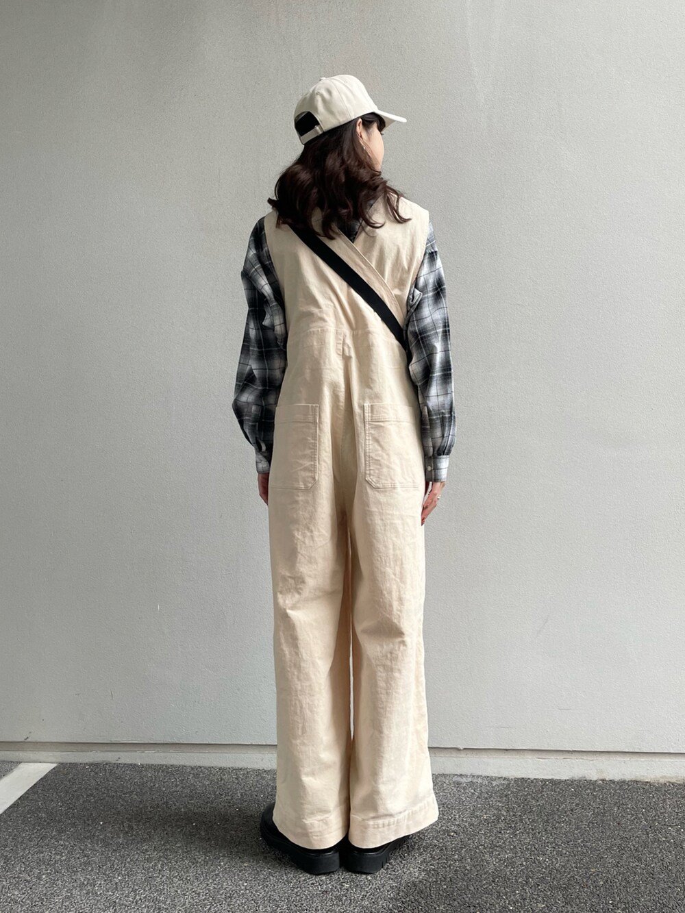 ホワイト系のシャツ/ブラウス、ホワイト系のサロペット/オーバーオール、ブラック系のショルダーバッグを着用したレディースの冬コーディネートの3枚目の写真