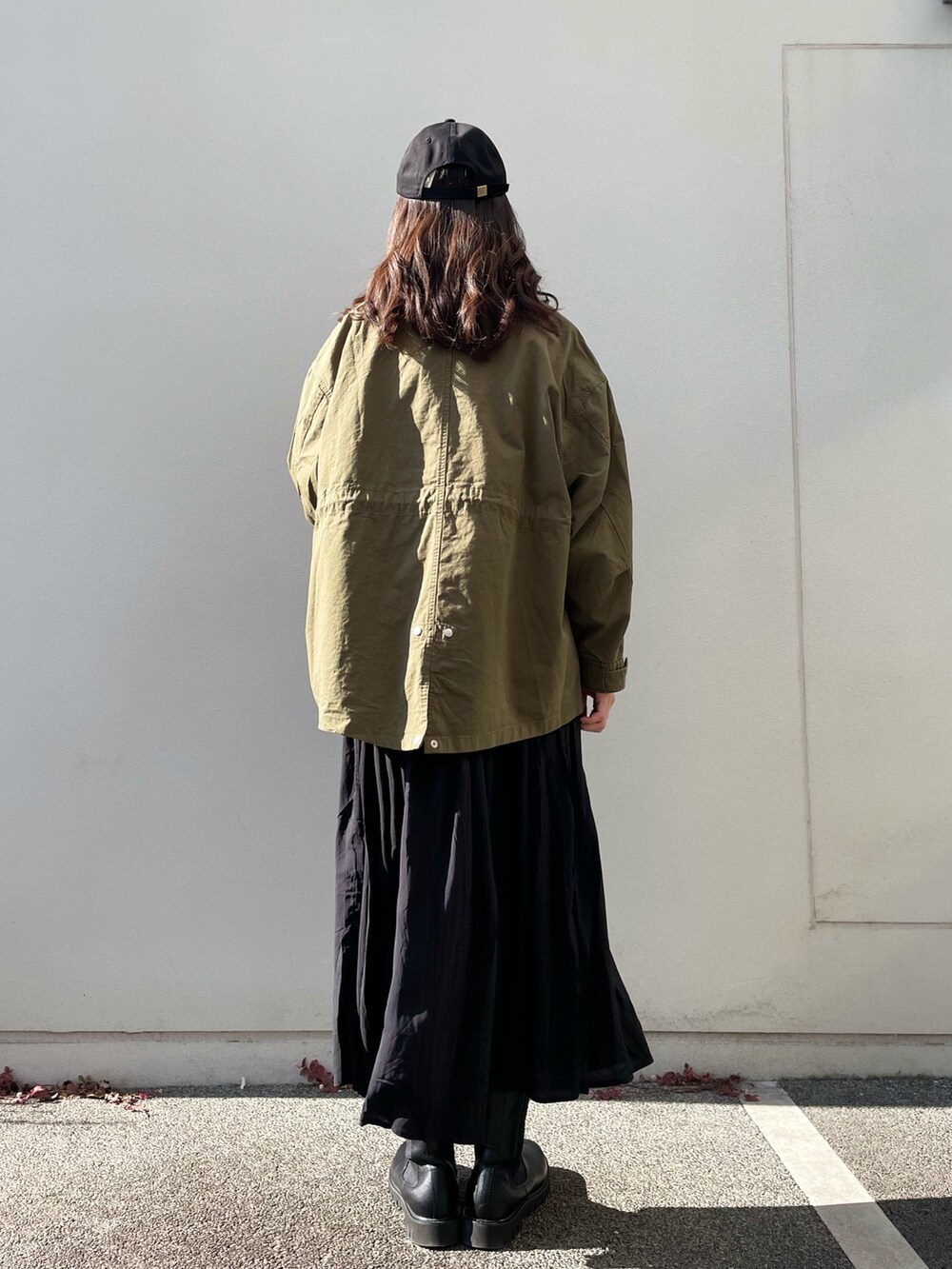 グリーン系のミリタリージャケット、ブラック系のワンピース、ブラック系のキャップを着用したレディースの冬コーディネートの3枚目の写真