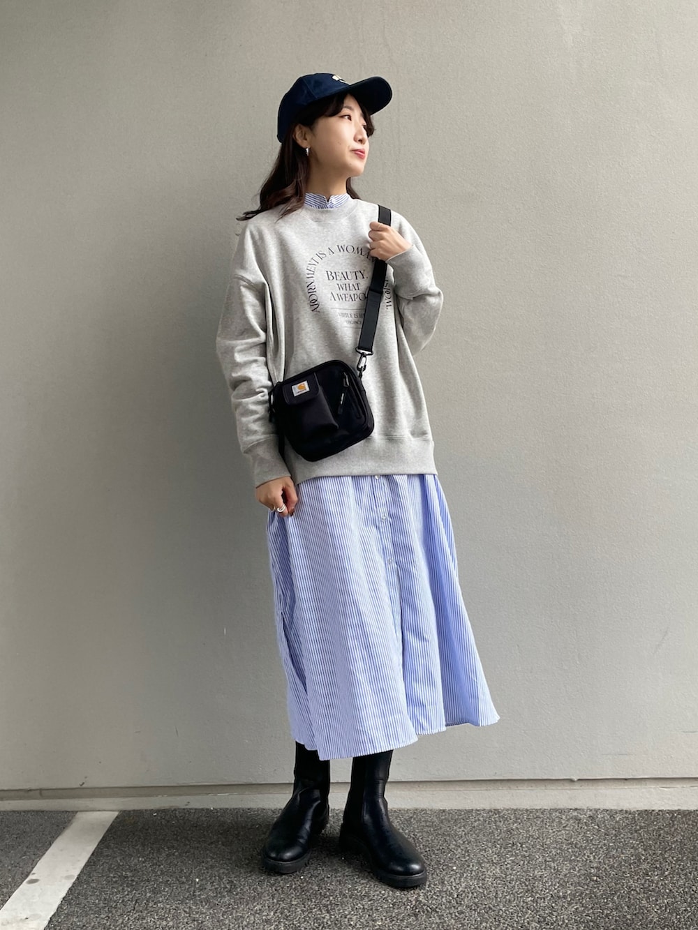 ブラック系のショルダーバッグ、グレー系のスウェット、ブルー系のシャツワンピースを着用したレディースの冬コーディネートの2枚目の写真