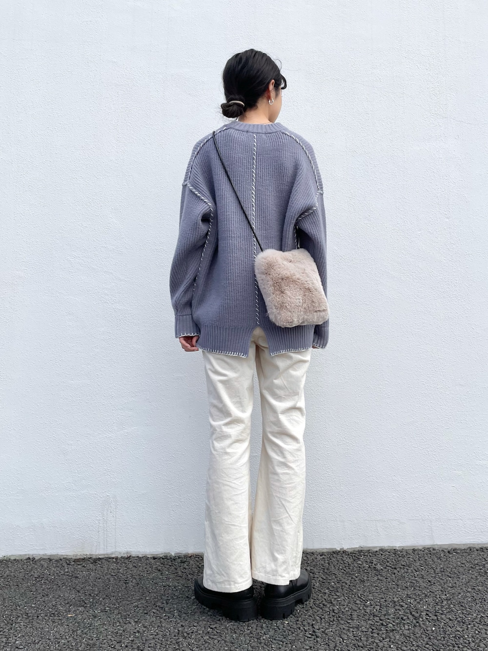 ブルー系のニット/セーター、ブルー系のショルダーバッグ、ブラック系のブーツを着用したレディースの冬コーディネートの2枚目の写真