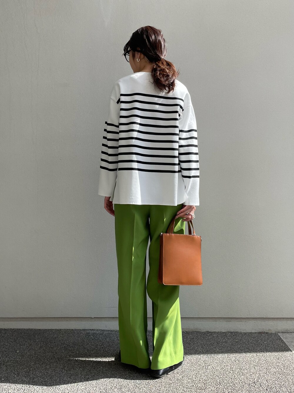 ホワイト系のニット/セーター、グリーン系のその他パンツ、ブラウン系のトートバッグを着用したレディースの冬コーディネートの3枚目の写真