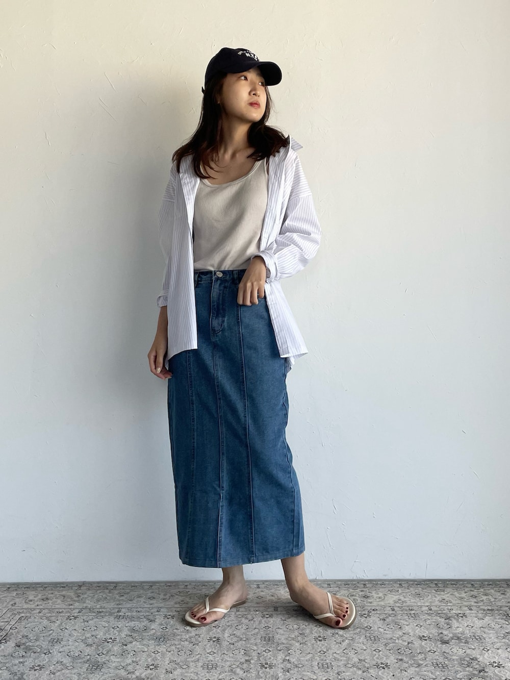 ホワイト系のシャツ/ブラウス、ブルー系のデニムスカート、ブルー系のキャップを着用したレディースの夏コーディネートの2枚目の写真