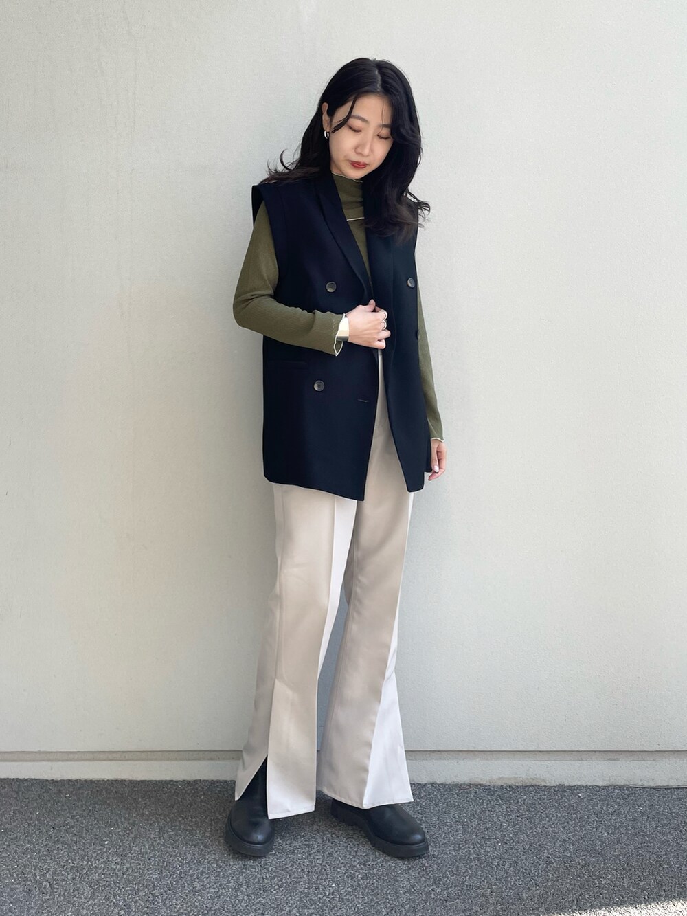 グリーン系のTシャツ/カットソー、ベージュ系のスラックス、ブラック系のベストを着用したレディースの春コーディネートの2枚目の写真