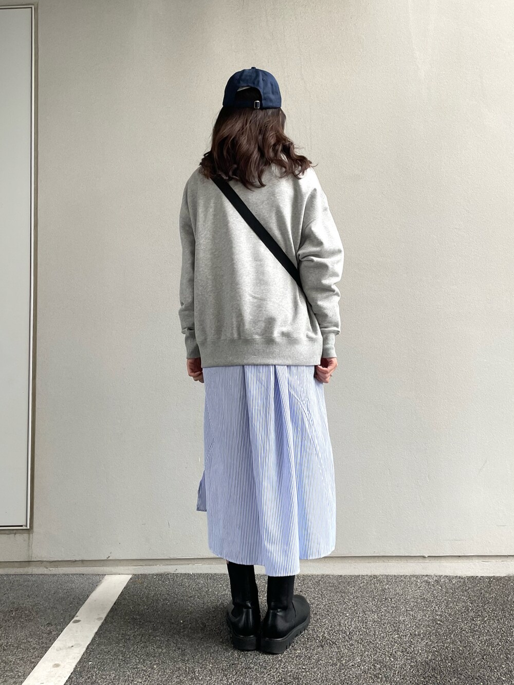 ブラック系のショルダーバッグ、グレー系のスウェット、ブルー系のシャツワンピースを着用したレディースの冬コーディネートの4枚目の写真