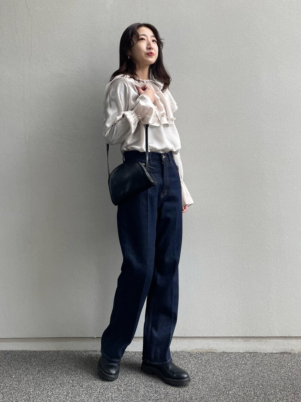 ホワイト系のシャツ/ブラウス、ブルー系のデニムパンツ、ブラック系のショルダーバッグを着用したレディースの冬コーディネートの2枚目の写真