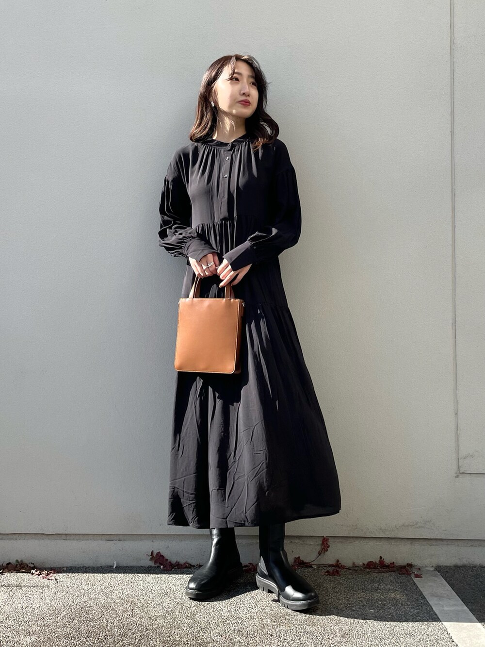 ブラック系のワンピース、ブラウン系のトートバッグを着用したレディースの冬コーディネートの2枚目の写真