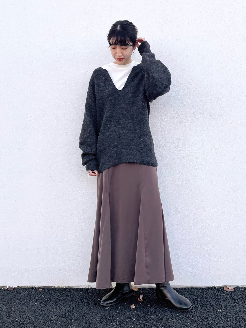 ブルー系のニット/セーター、ブラウン系のスカート、ベージュ系のTシャツ/カットソーを着用したレディースの冬コーディネートの2枚目の写真