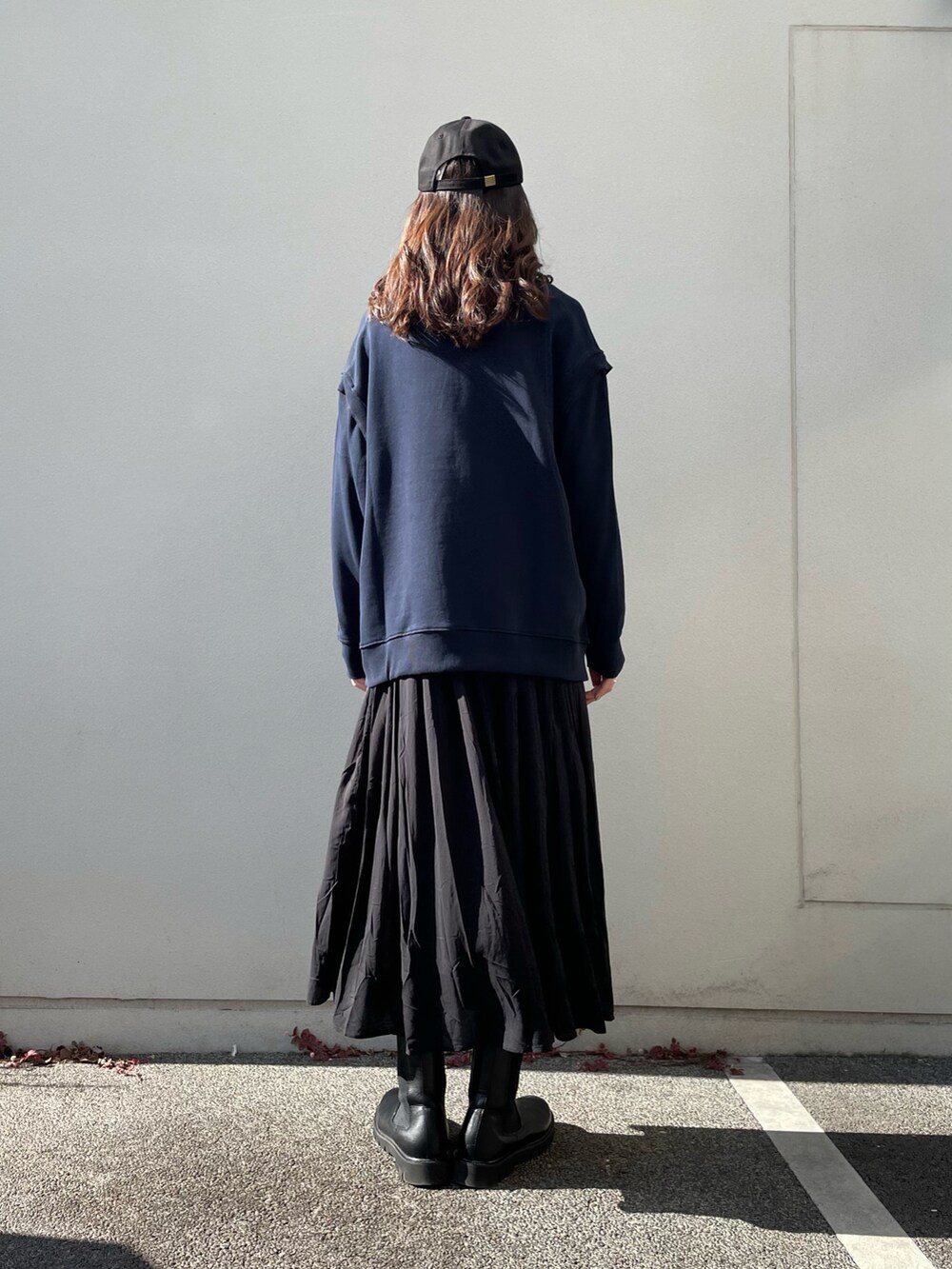 ブルー系のトップス、ブラック系のワンピース、ブラック系のキャップを着用したレディースの冬コーディネートの3枚目の写真