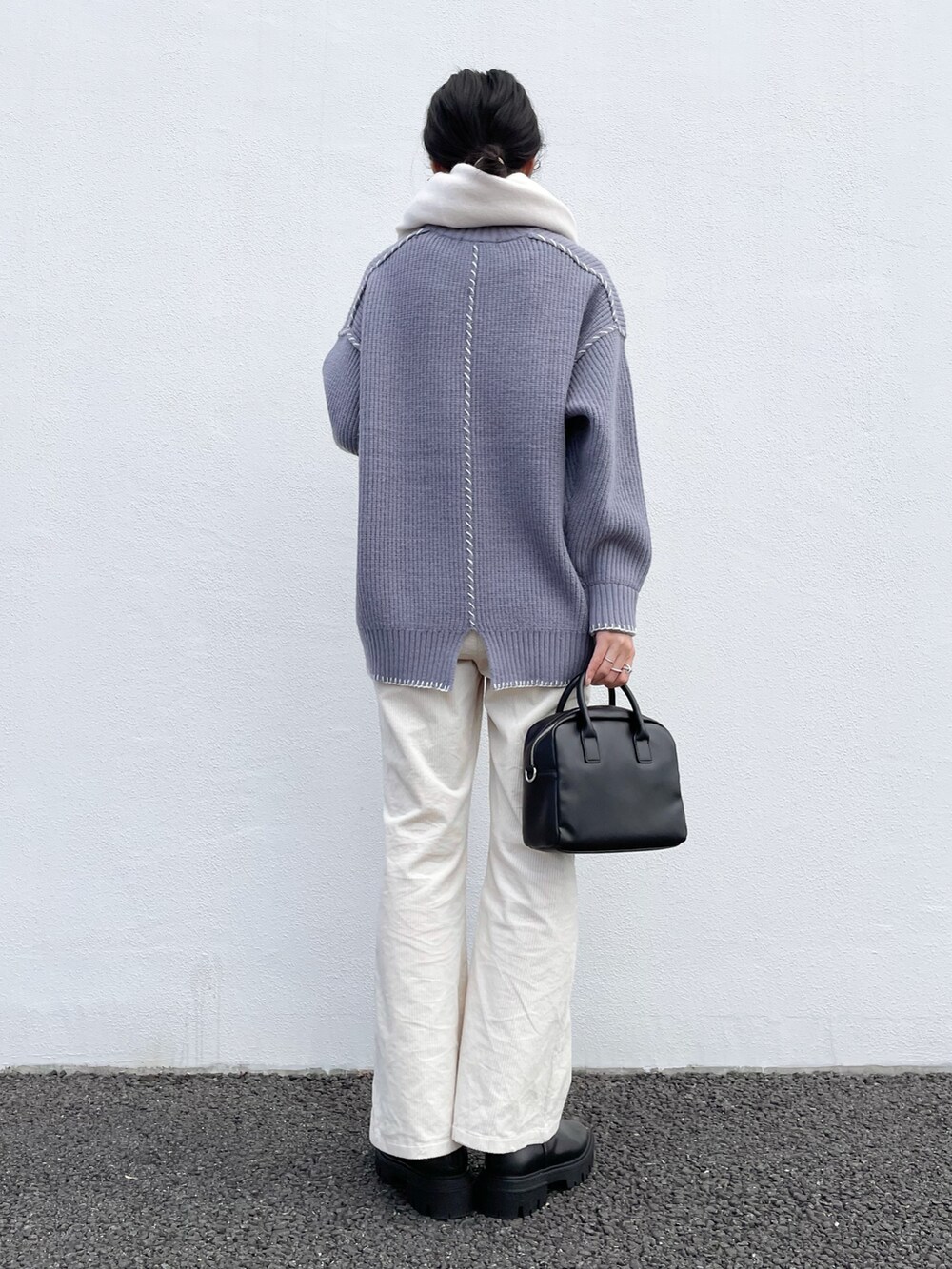 ブルー系のニット/セーター、ブラック系のブーツ、ブラック系のボストンバッグを着用したレディースの冬コーディネートの2枚目の写真