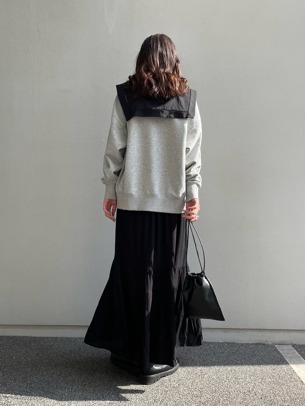 グレー系のスウェット、ブラック系のシャツ/ブラウス、オレンジ系のスカートを着用したレディースの冬コーディネートの3枚目の写真