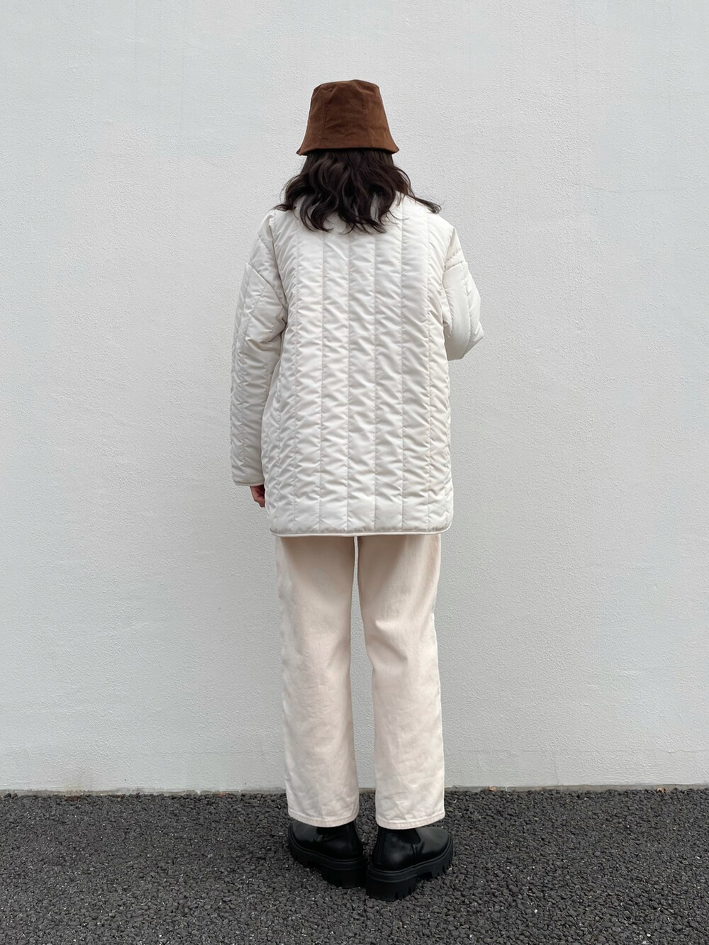 ホワイト系のナイロンジャケット、ホワイト系のTシャツ/カットソー、ブラック系のブーツを着用したレディースの冬コーディネートの3枚目の写真