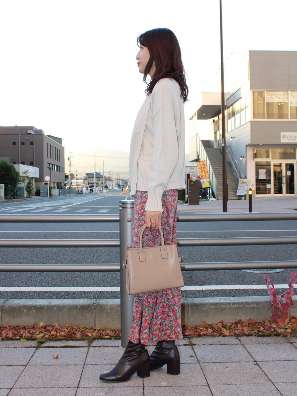 ホワイト系のニット/セーター、ブルー系のスカート、ブラウン系のブーツを着用したレディースの秋コーディネートの2枚目の写真