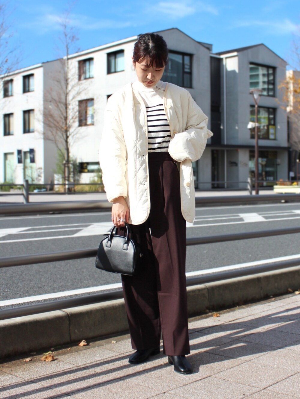 ホワイト系のその他アウター、ホワイト系のニット/セーター、ブラック系のショルダーバッグを着用したレディースの秋コーディネートの2枚目の写真
