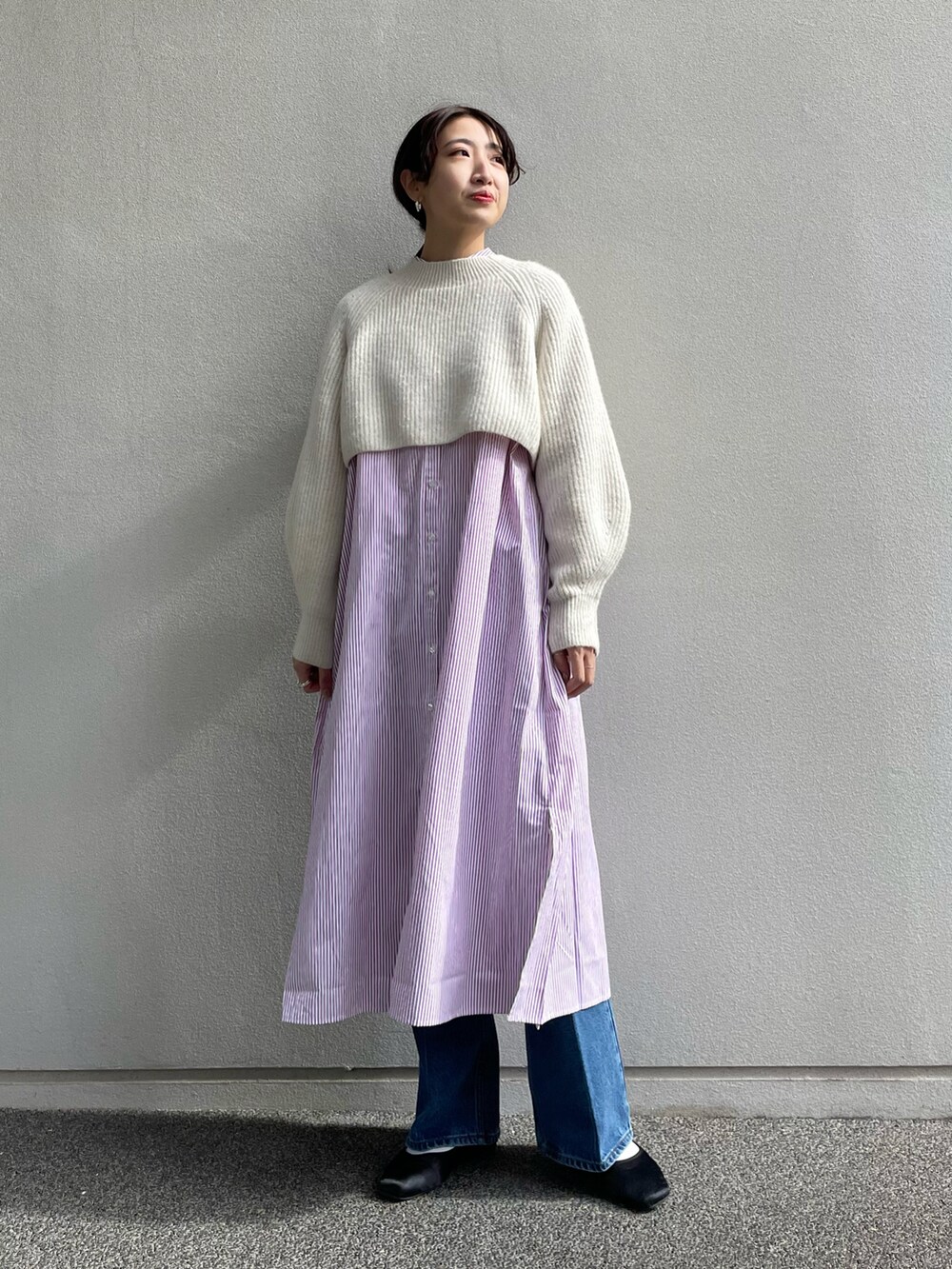 ホワイト系のニット/セーター、パープル系のシャツワンピース、ブルー系のデニムパンツを着用したレディースの冬コーディネートの2枚目の写真