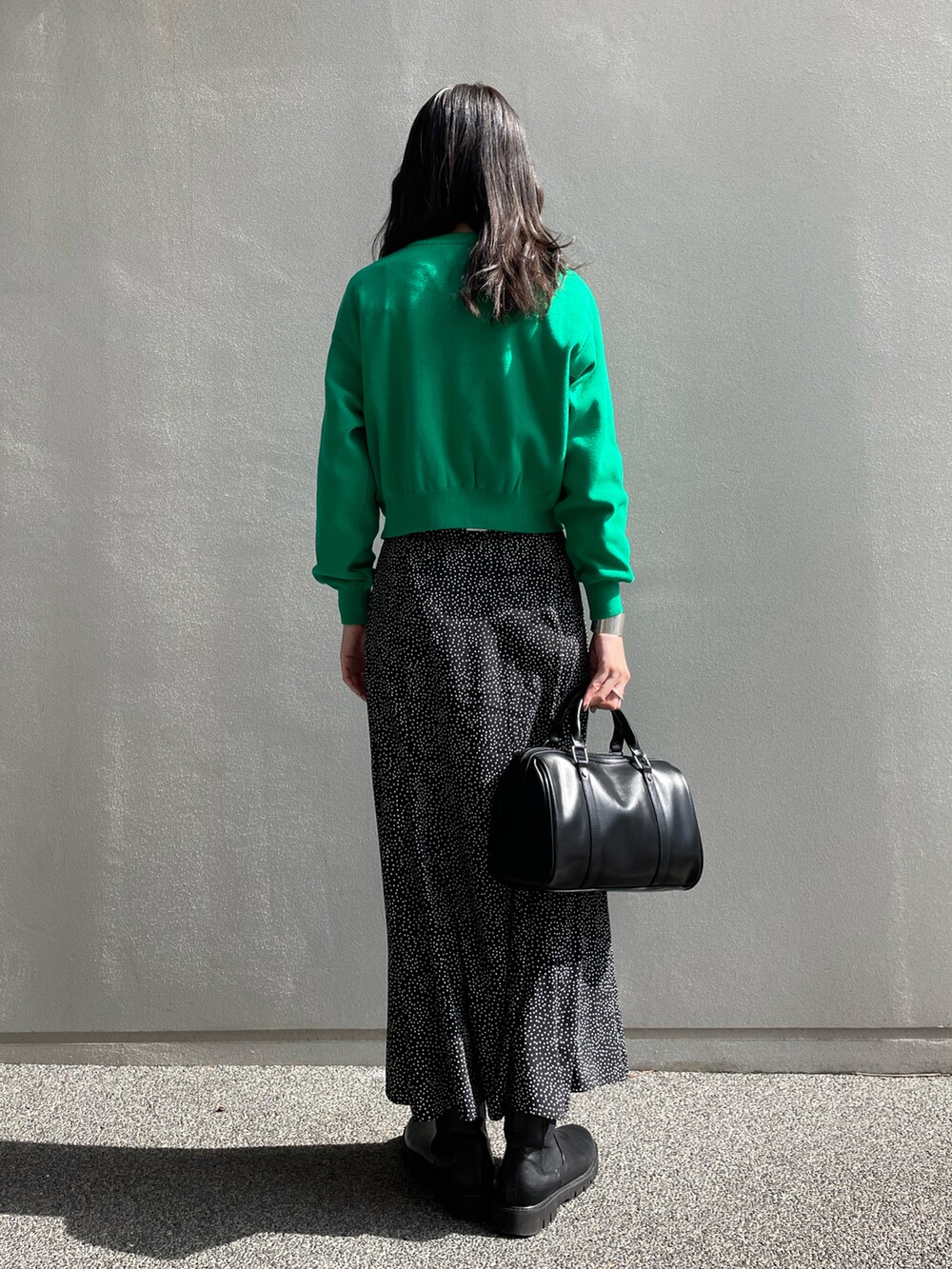 グリーン系のカーディガン/ボレロ、ブラック系のボストンバッグ、ブラック系のスカートを着用したレディースの春コーディネートの3枚目の写真