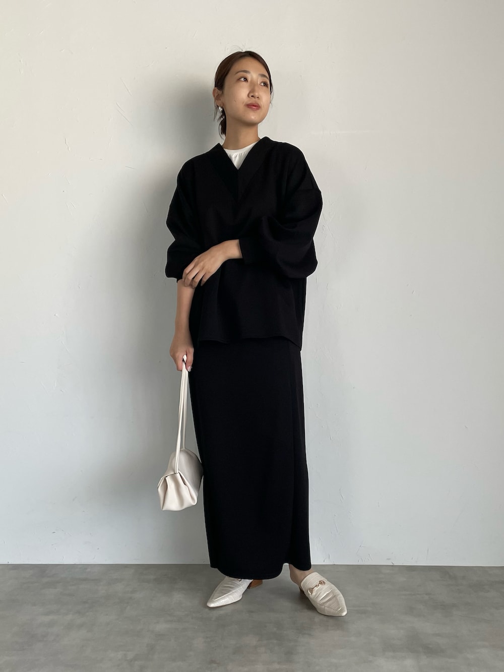 ブラウン系のスウェット、ベージュ系のスカート、ブラウン系のハンドバッグを着用したレディースの夏コーディネートの3枚目の写真