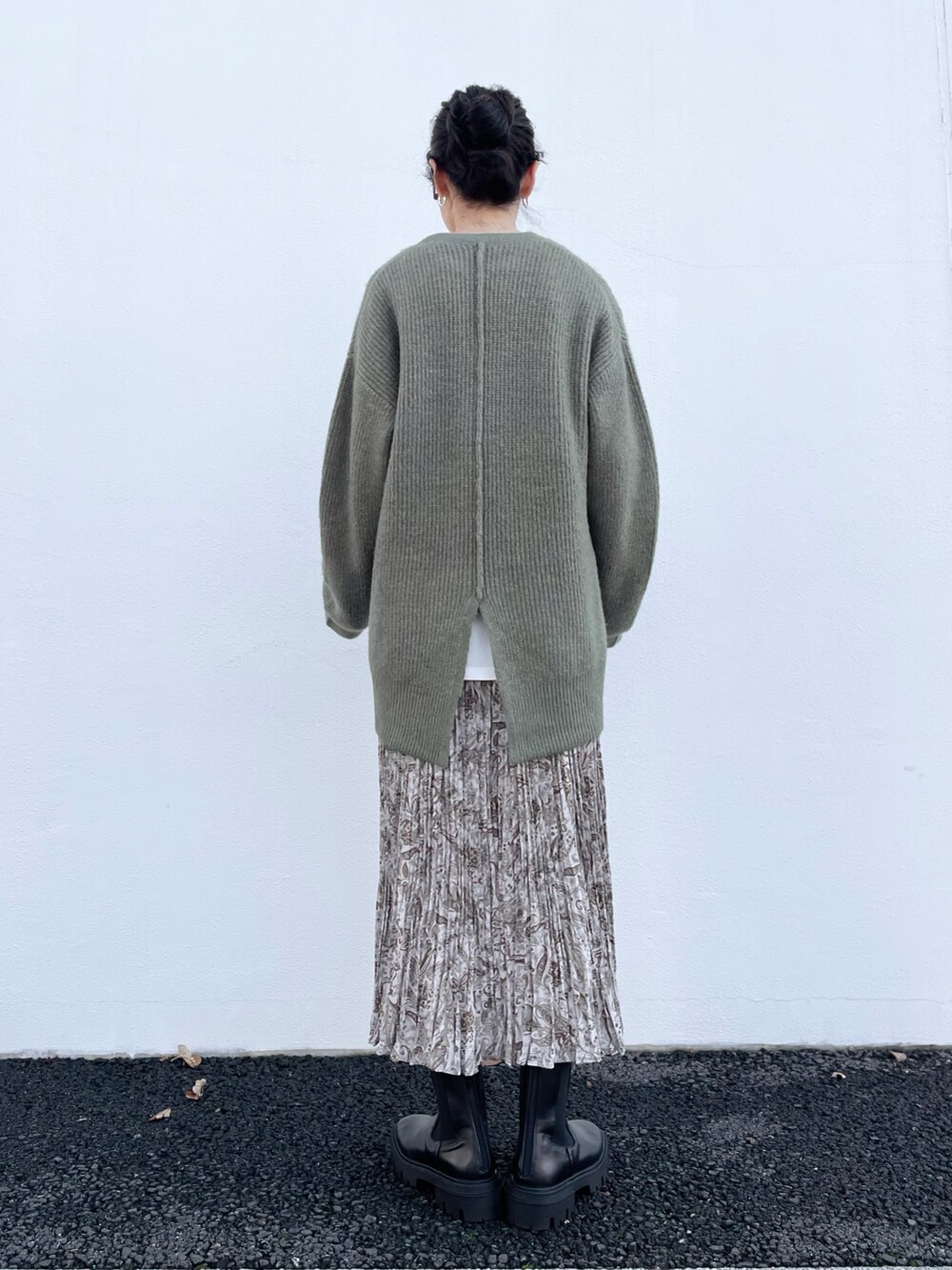 グリーン系のニット/セーター、ベージュ系のスカート、ベージュ系のTシャツ/カットソーを着用したレディースの秋コーディネートの3枚目の写真