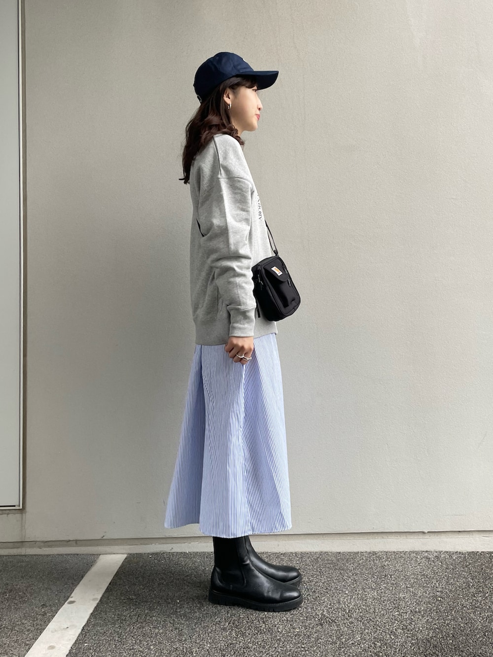 ブラック系のショルダーバッグ、グレー系のスウェット、ブルー系のシャツワンピースを着用したレディースの冬コーディネートの3枚目の写真