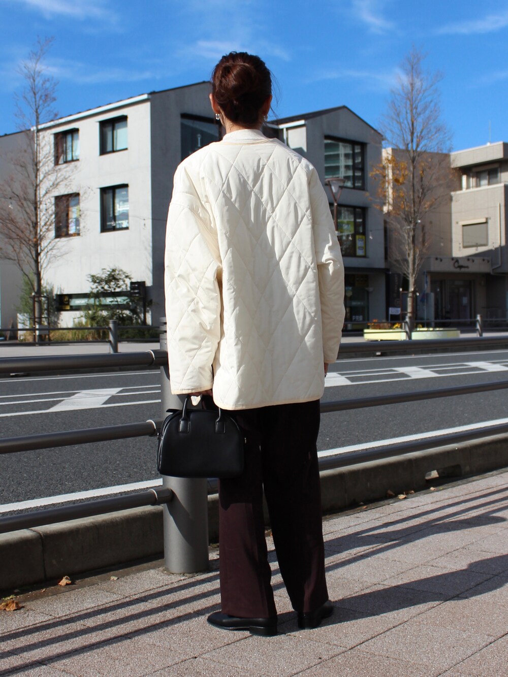 ホワイト系のその他アウター、ホワイト系のニット/セーター、ブラック系のショルダーバッグを着用したレディースの秋コーディネートの4枚目の写真