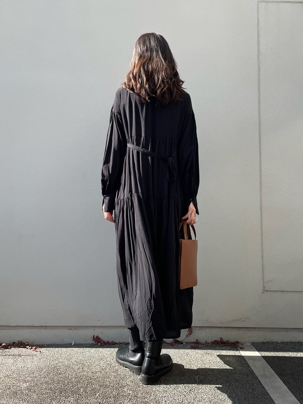 ブラック系のワンピース、ブラウン系のトートバッグを着用したレディースの冬コーディネートの3枚目の写真