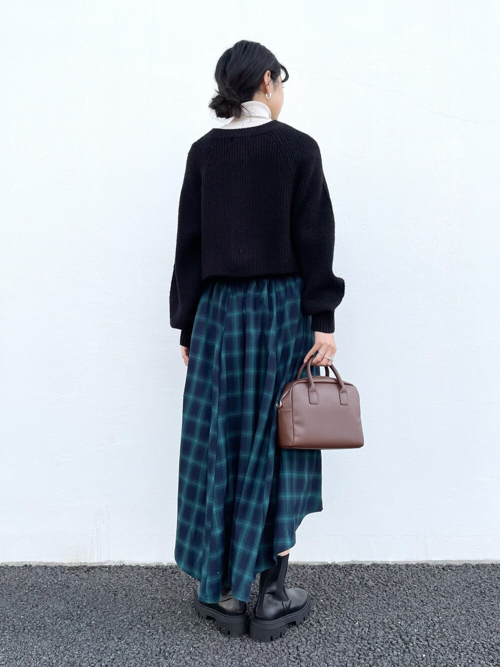 ブラック系のブーツ、ホワイト系のニット/セーター、ブラック系のカーディガン/ボレロを着用したレディースの冬コーディネートの2枚目の写真